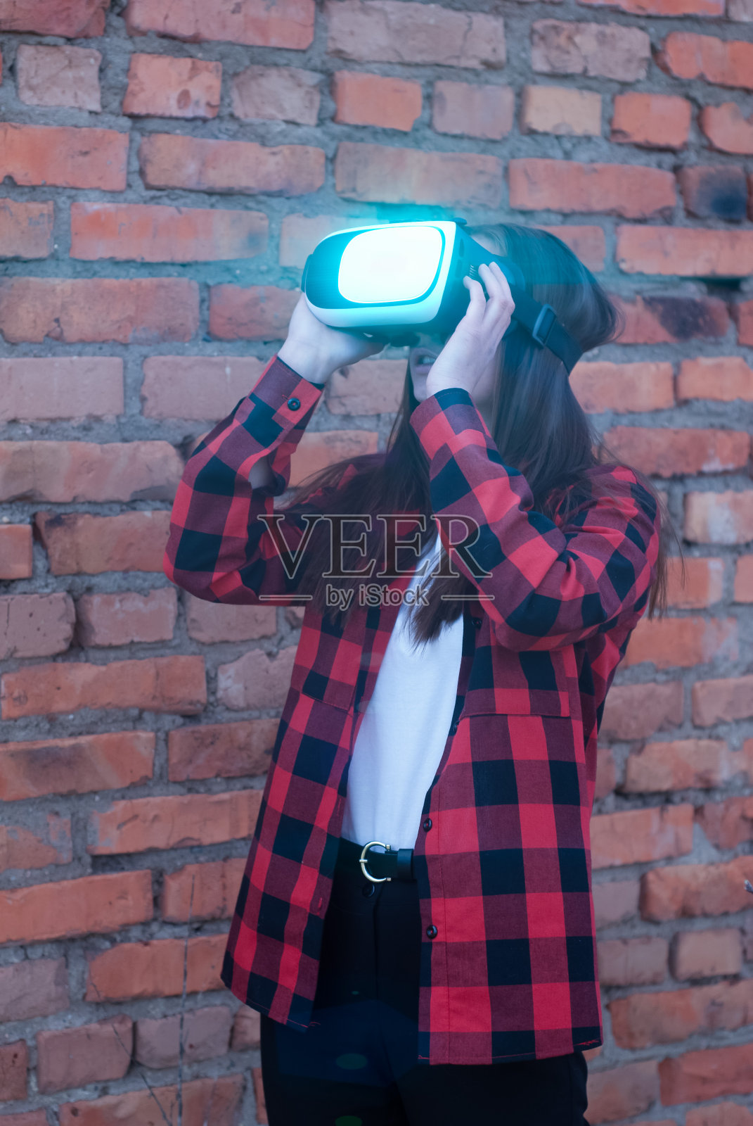 穿红衬衫的女孩戴着VR眼镜看视频，照片摄影图片