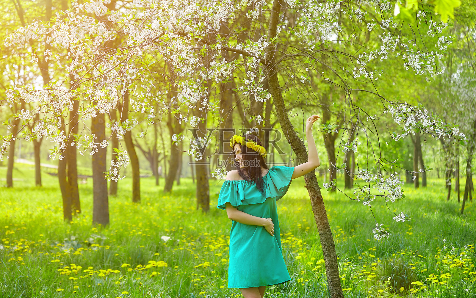 美丽的女孩头上戴着蒲公英的花环，享受春天照片摄影图片