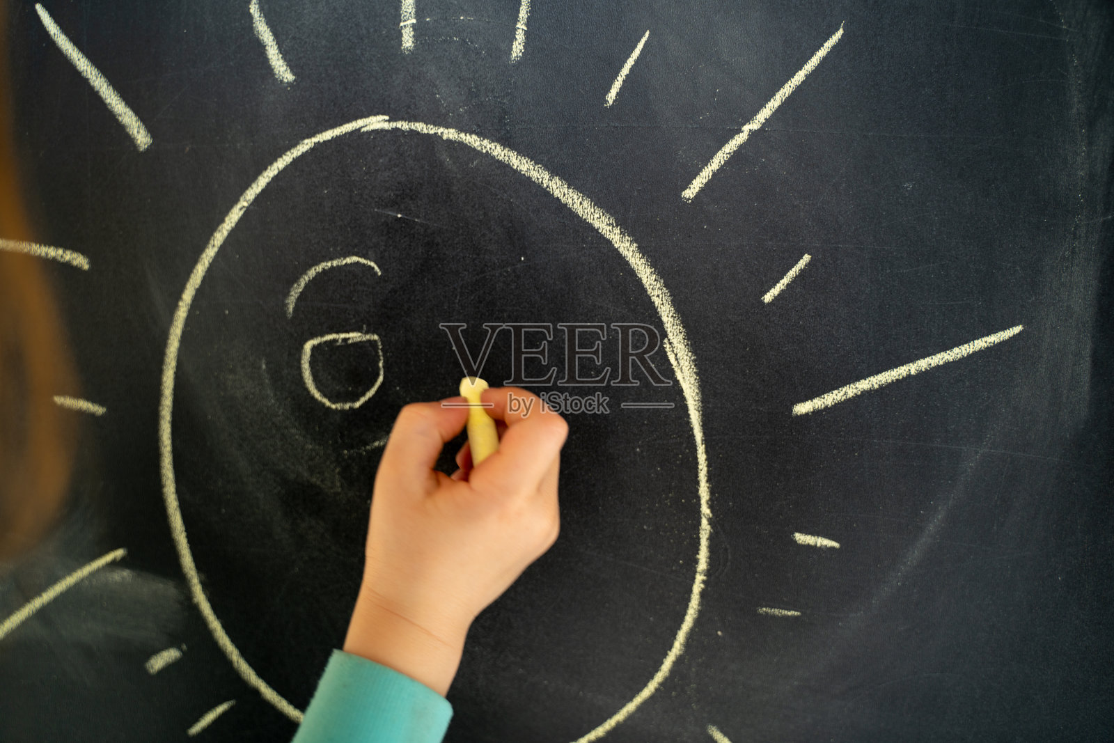 孩子在家里的黑板上画太阳照片摄影图片