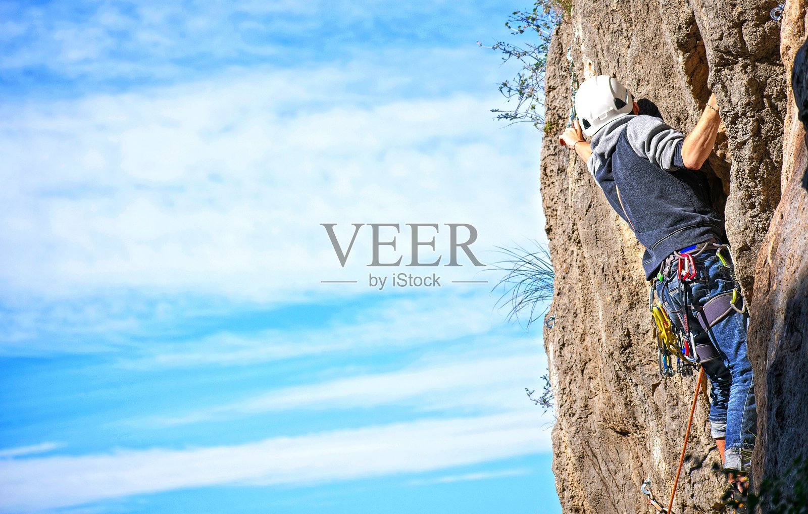 运动员在蓝天下爬山。照片摄影图片