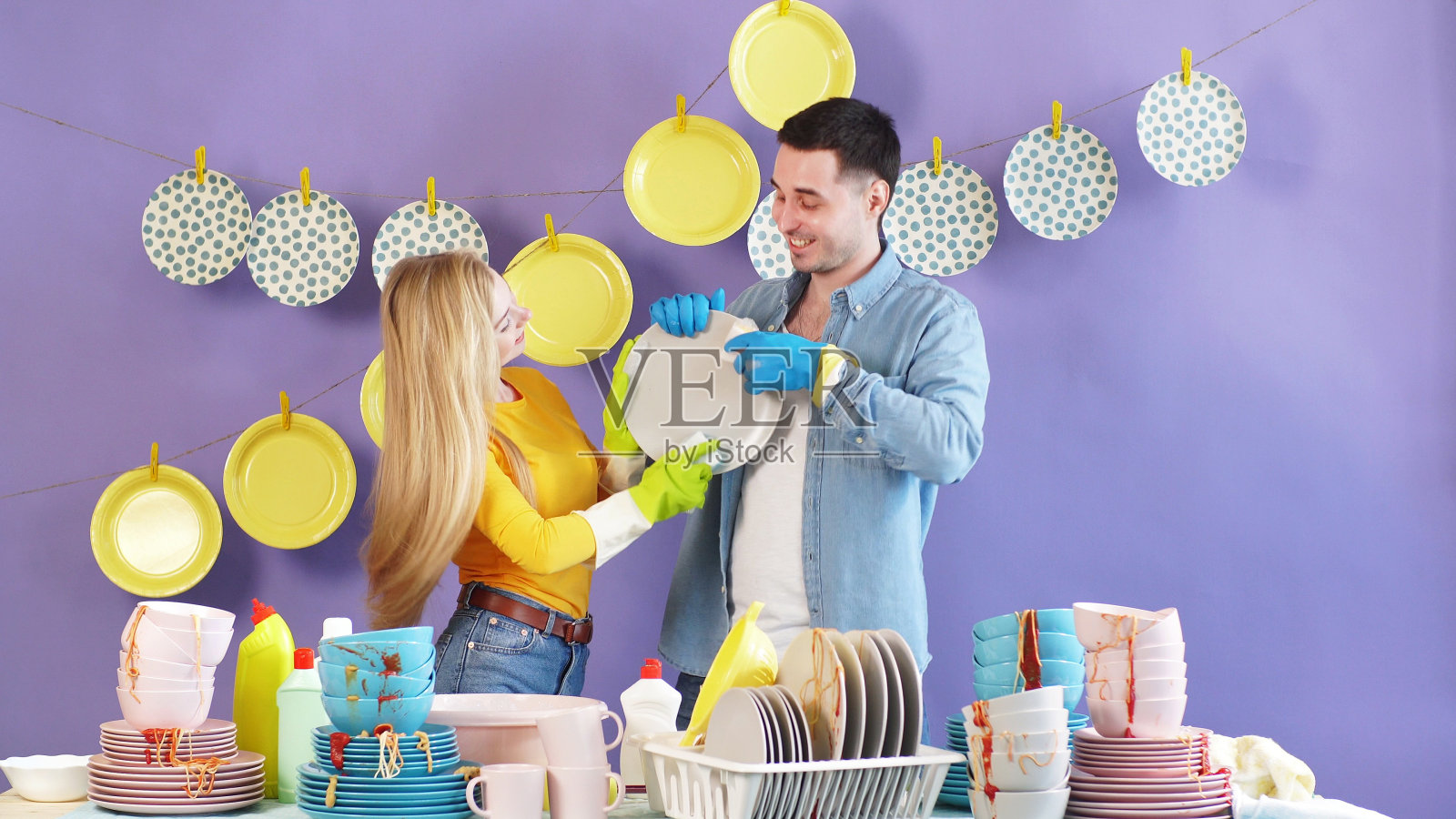 一对年轻夫妇，一男一女，看着对方，洗碗擦盘子。幸福，家人一起做一切事照片摄影图片