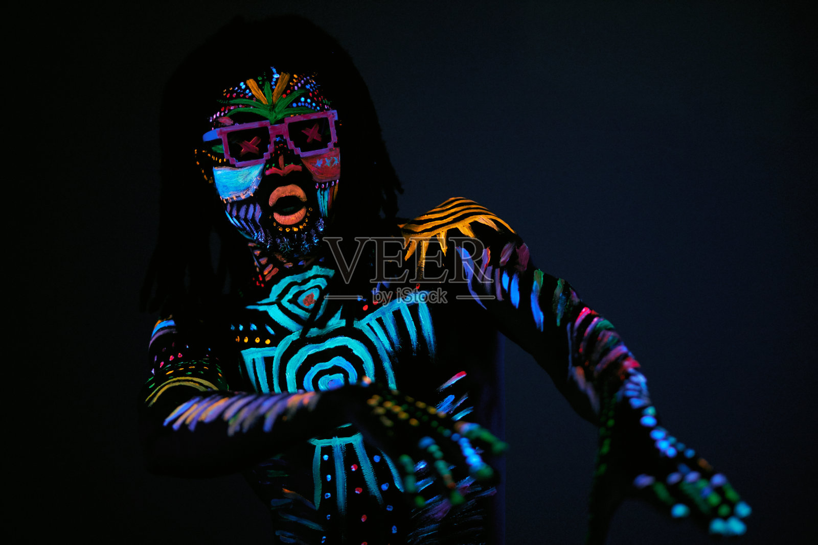 紫外线下荧光图案的帅气舞者照片摄影图片