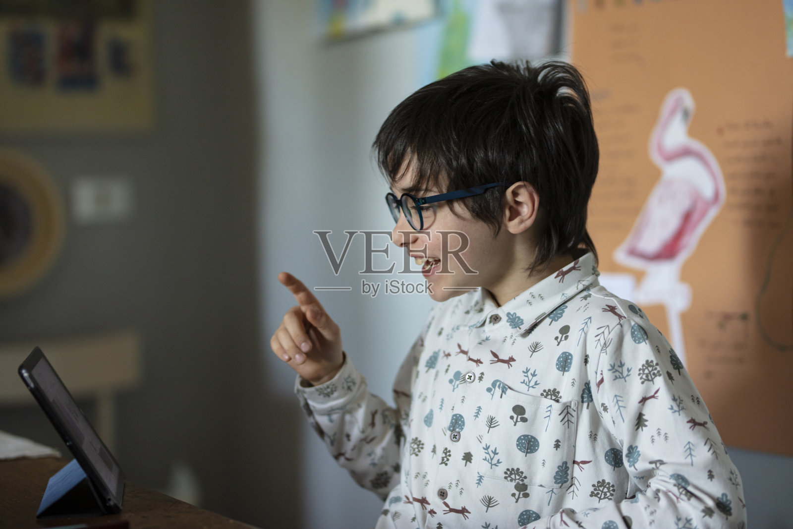 一位英俊的9岁男孩正在通过平板电脑在课堂上进行网络教学照片摄影图片