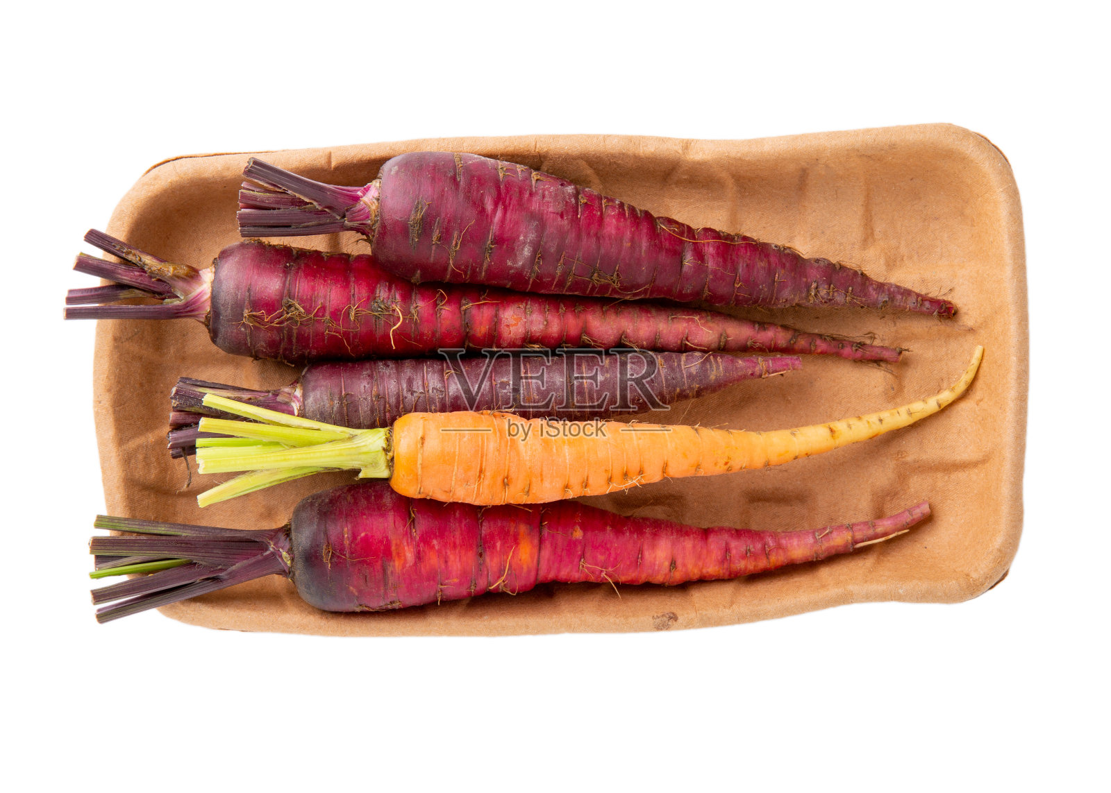 一堆五颜六色的生胡萝卜放在白色的纸盘上。前视图。照片摄影图片