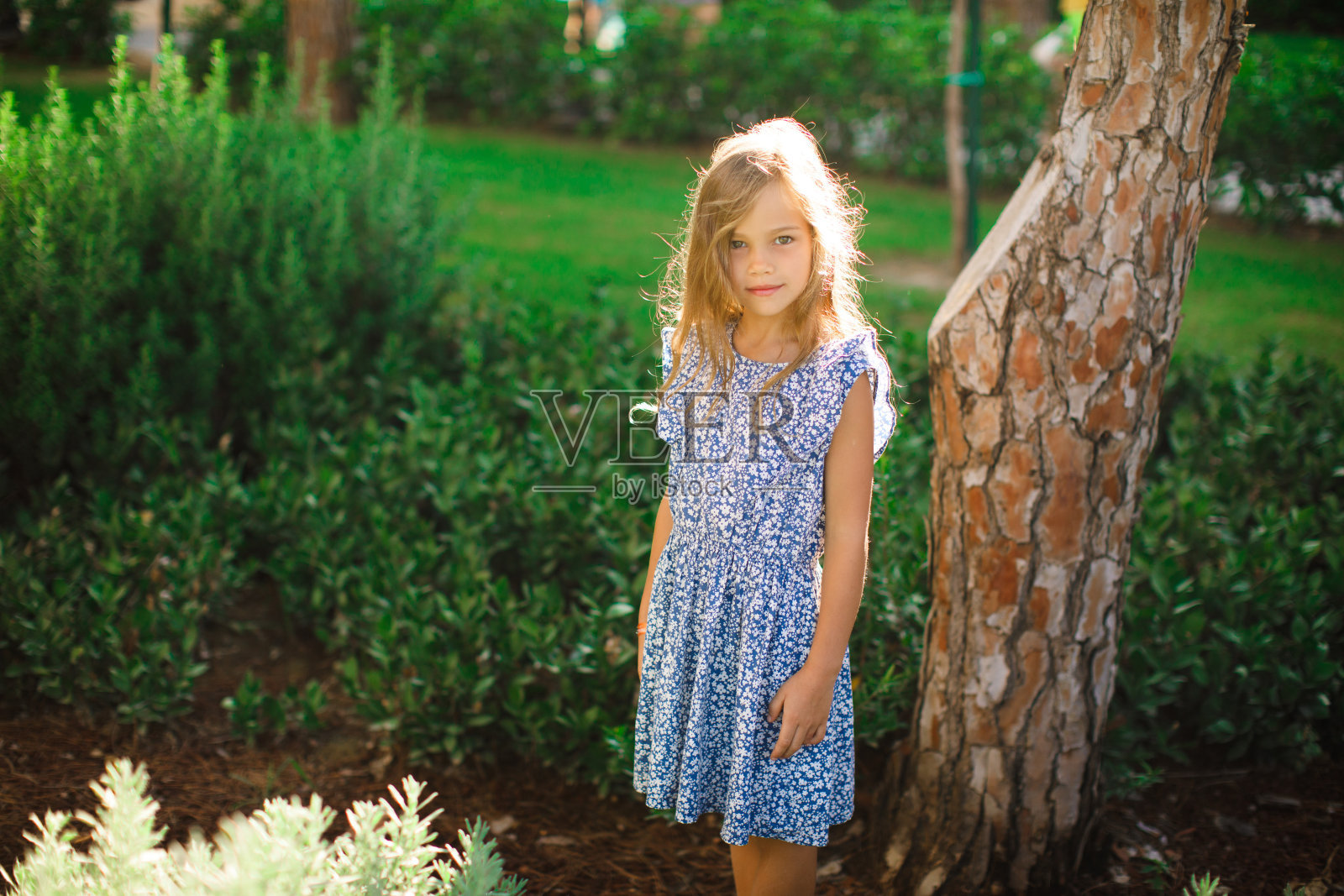 小女孩站在公园里照片摄影图片