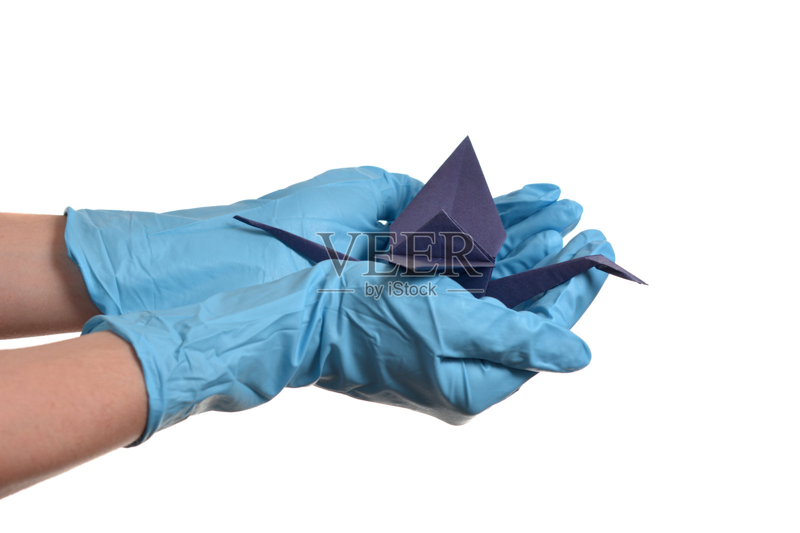 折纸鹤手拿橡胶手套罩白色照片摄影图片