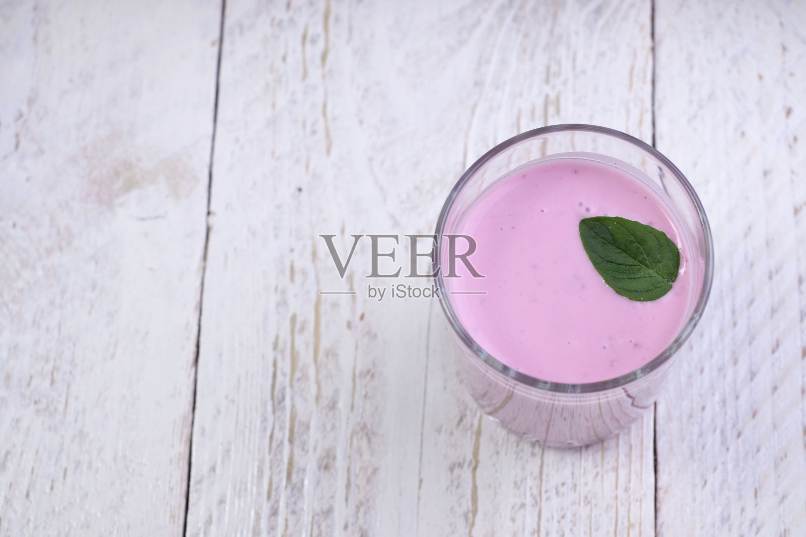 玻璃杯蓝莓酸奶和薄荷在一个轻木制背景。照片摄影图片