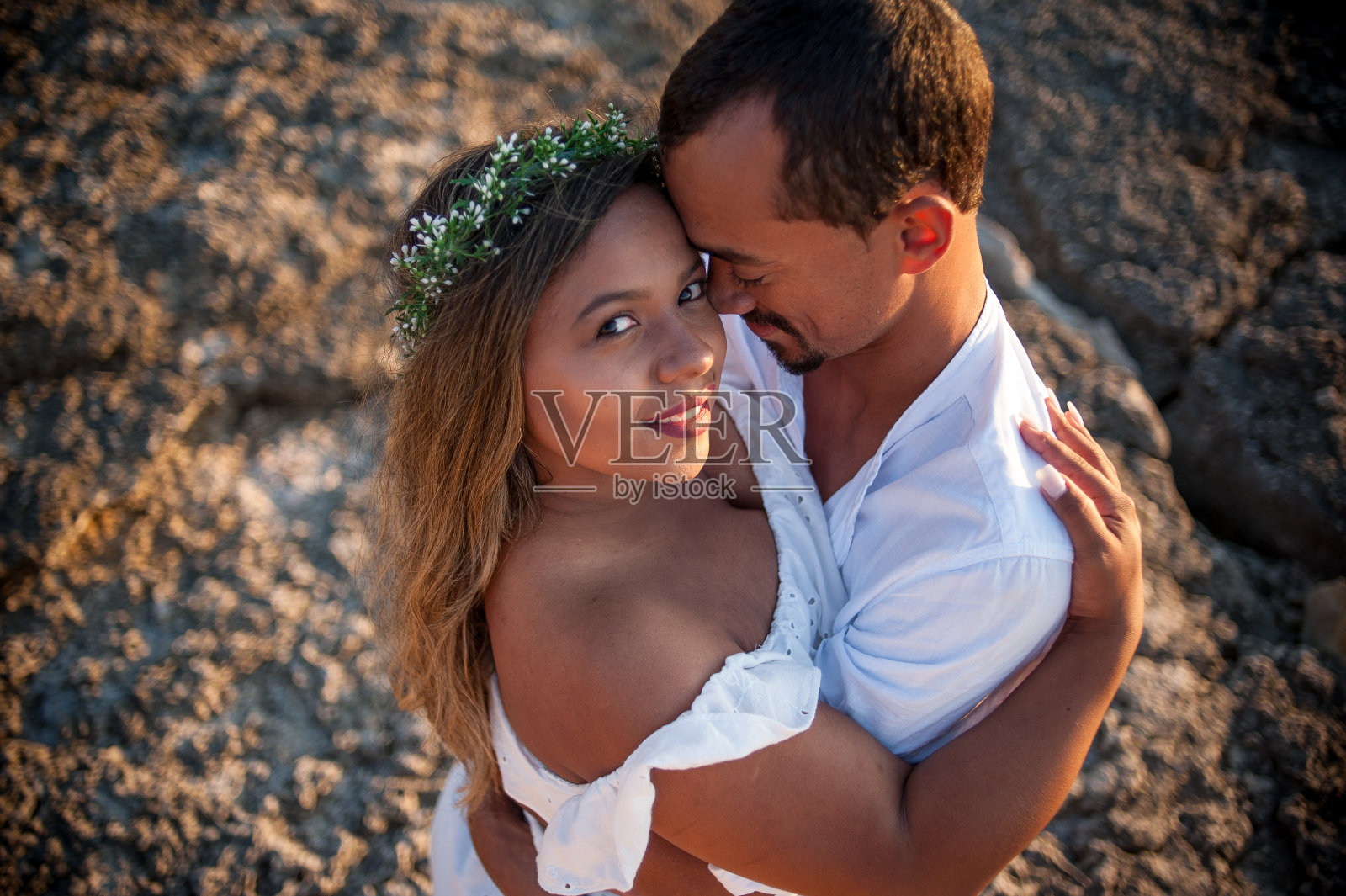 高视角的新娘和新郎拥抱。她正看着照相机。照片摄影图片