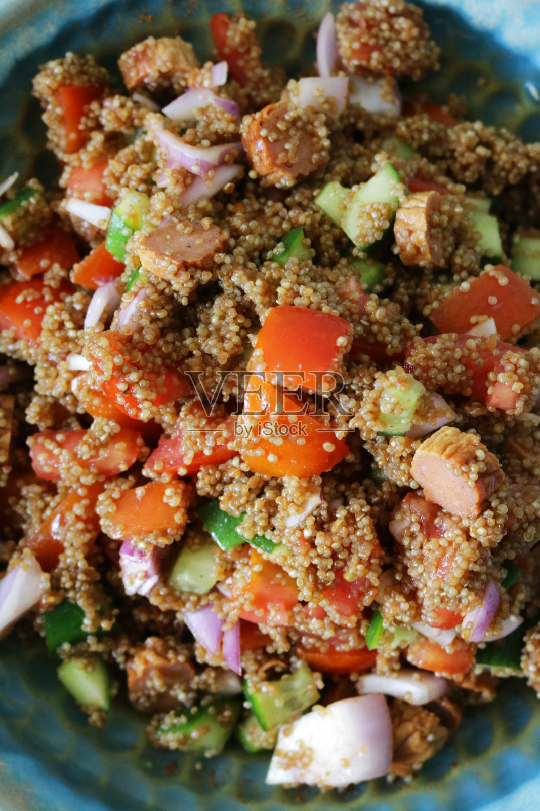 碗里的藜麦沙拉食谱，香肠片，黄瓜丁，番茄丁，红洋葱和羊乳酪照片摄影图片