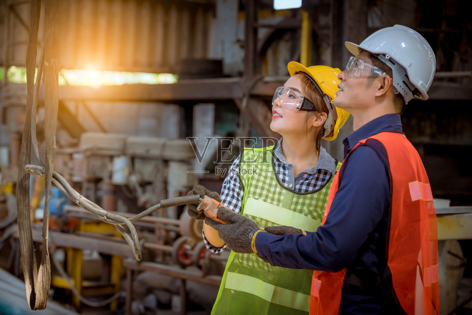 工业工程师和工人穿着安全制服在工厂生产线上控制滑动金属板机照片摄影图片