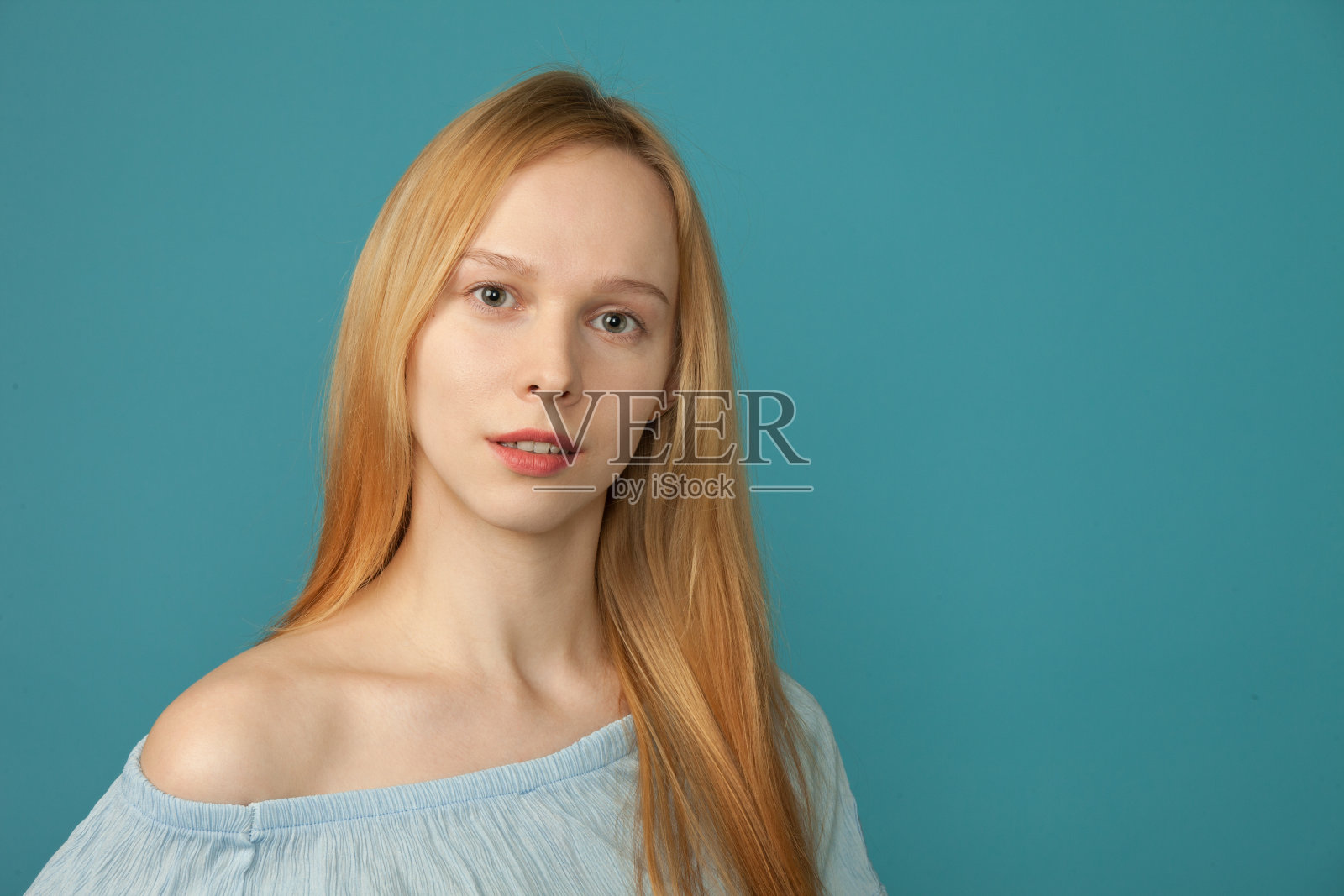 一名25岁女性在蓝色背景下的摄影肖像画照片摄影图片