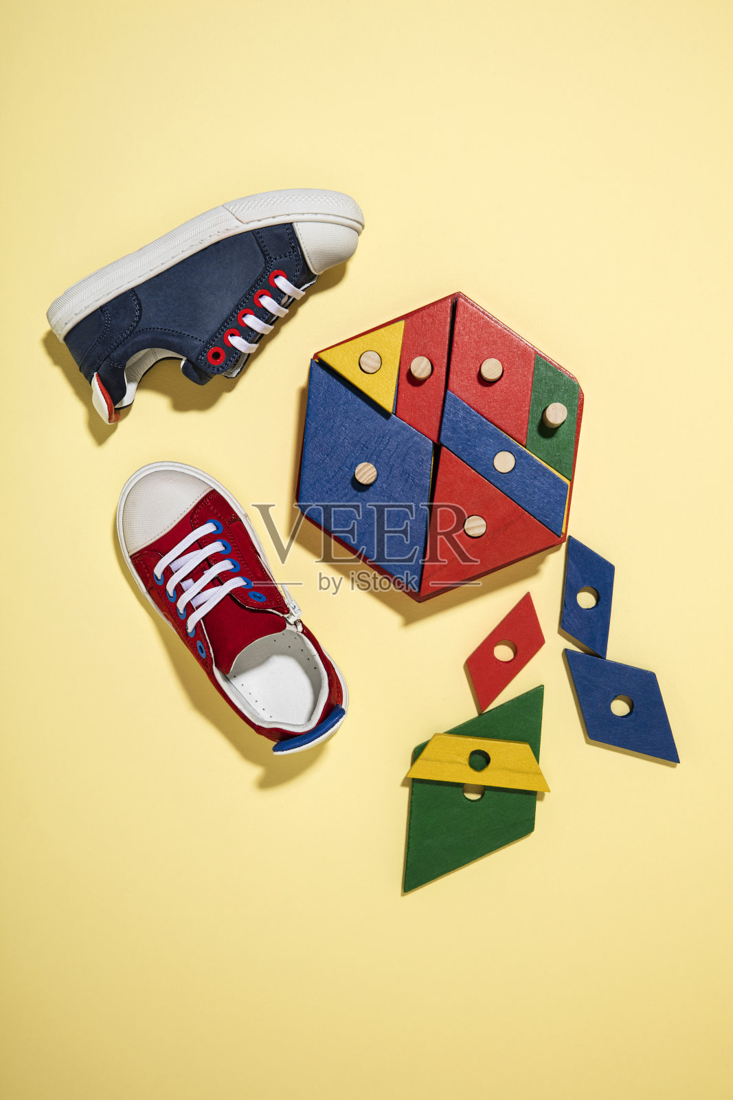 时髦的运动鞋与木制玩具孤立在黄色背景照片摄影图片