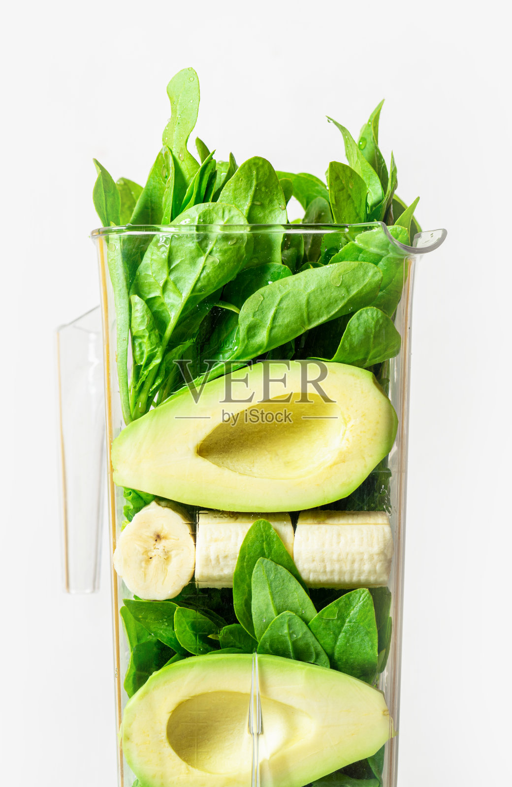 把鳄梨，香蕉和菠菜放在搅拌机里照片摄影图片