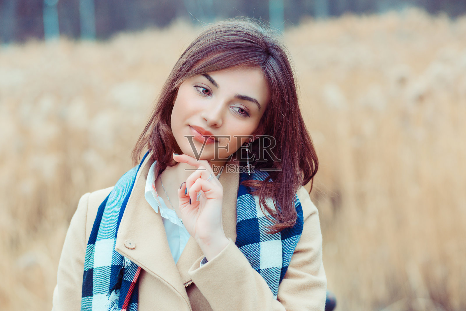 一个女人的性感肖像，美丽的脸女性享受自然，思考梦幻女孩米色外套和蓝白围巾的户外孤立在秋天的自然公园背景照片摄影图片