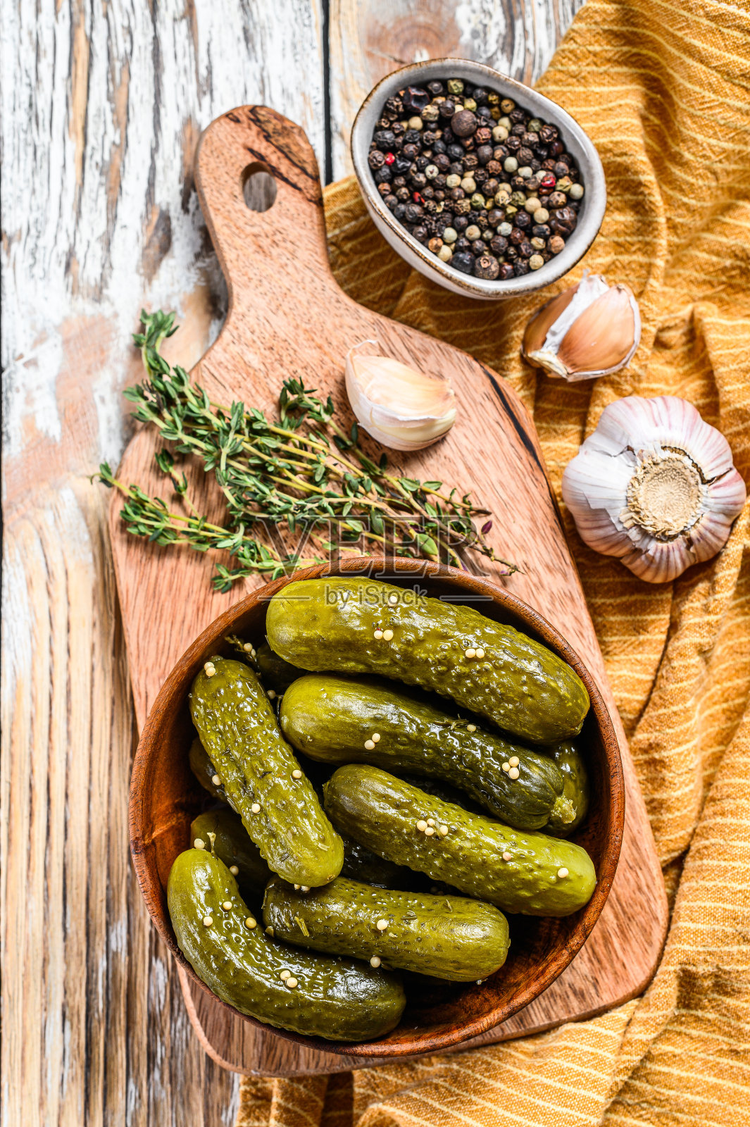 腌黄瓜小黄瓜放在木盘里。芥末和大蒜的泡菜。白色背景。俯视图照片摄影图片