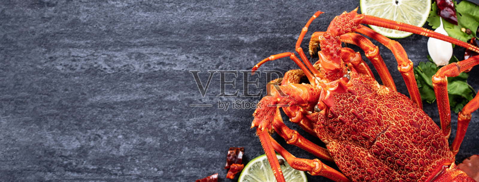 煮熟的龙虾，美味的晚餐海鲜套餐与刀叉在黑色的石板背景，餐厅菜单设计，俯视图，头顶照片摄影图片