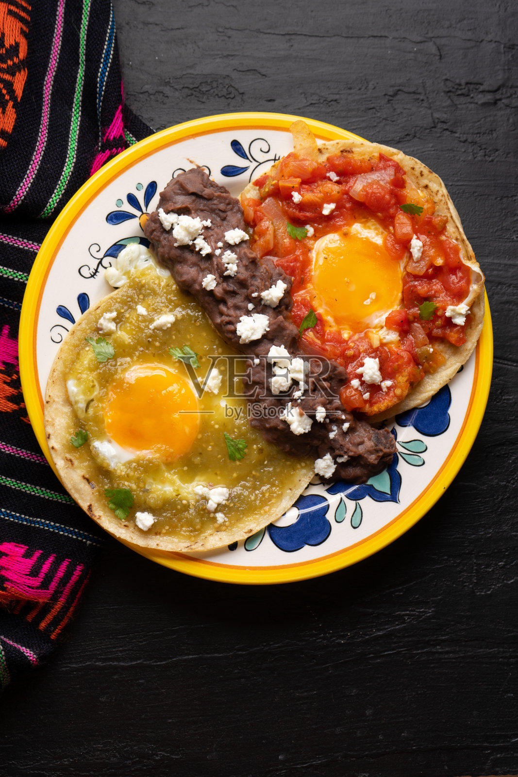 墨西哥煎蛋与绿色和红色的酱料也被称为“divorciados”在深色的背景照片摄影图片