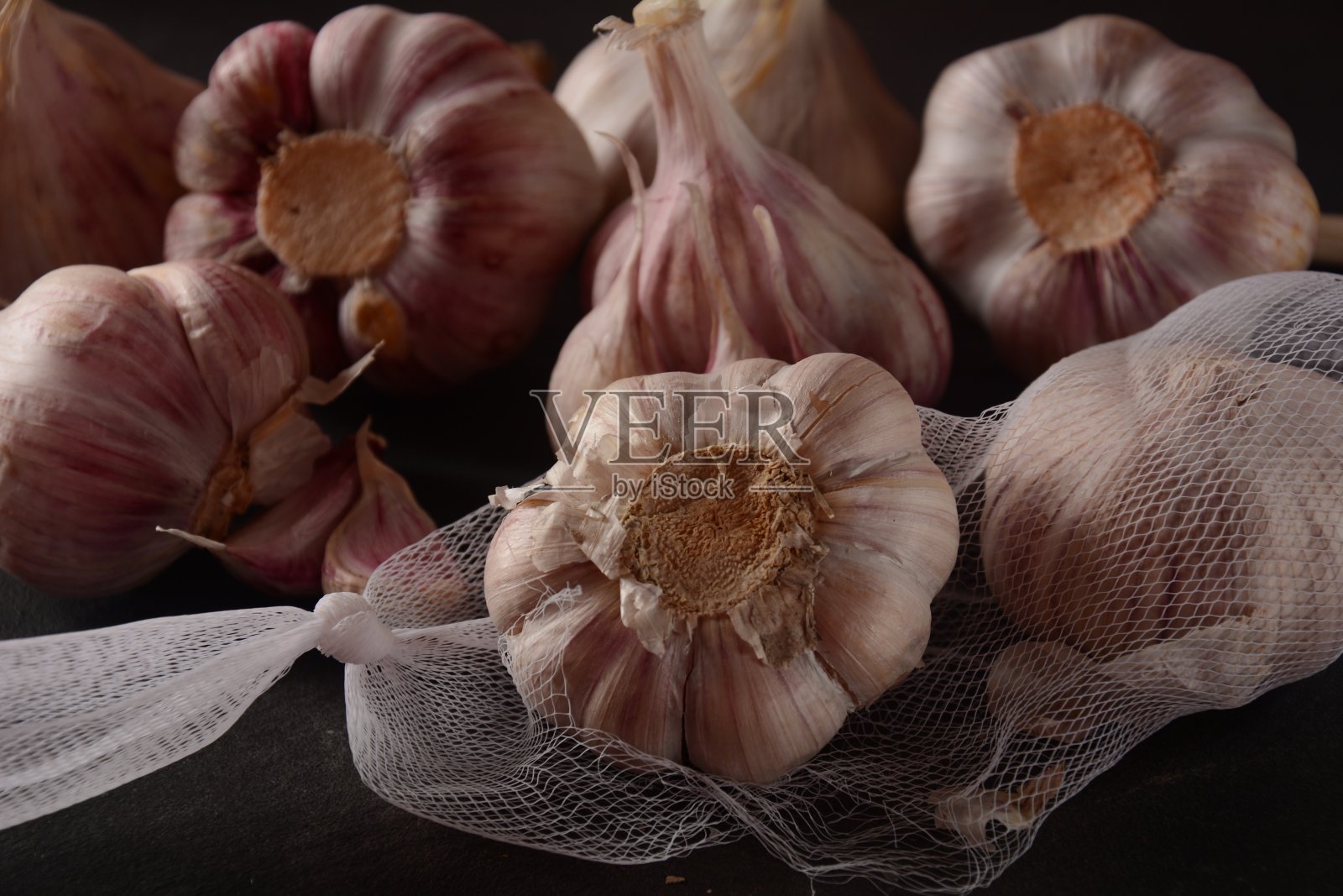 黑色背景上的大蒜特写、大蒜和蒜瓣照片摄影图片