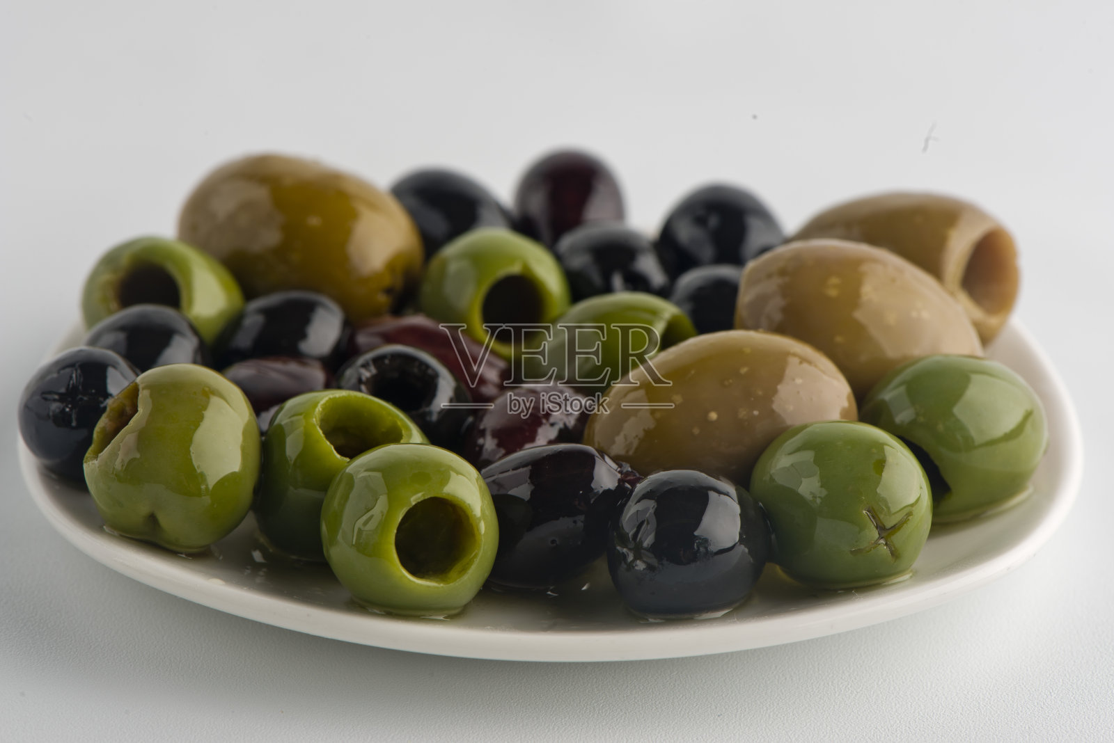 用特级初榨橄榄油、红椒片、香草和香料浸泡。经典的意大利或希腊开胃菜或配料。照片摄影图片