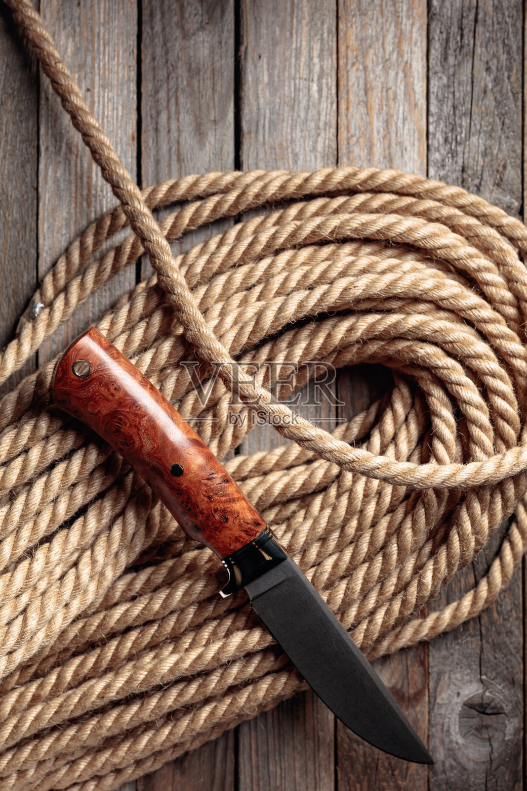 猎人战斗手工刀和麻绳木制背景。照片摄影图片