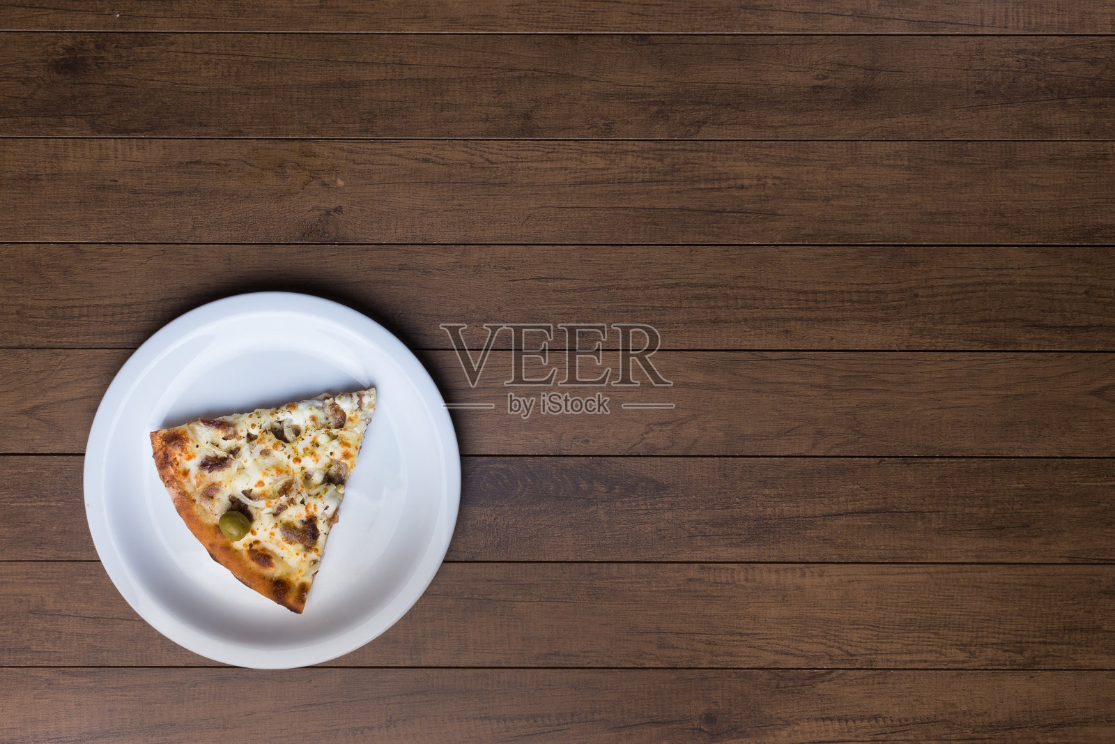 美味的披萨装在盘子里。肉披萨放在木板上。由马苏里拉奶酪，picanha肉，洋葱，奶酪，番茄酱和橄榄制成。菲力牛排。水平左下对齐。照片摄影图片