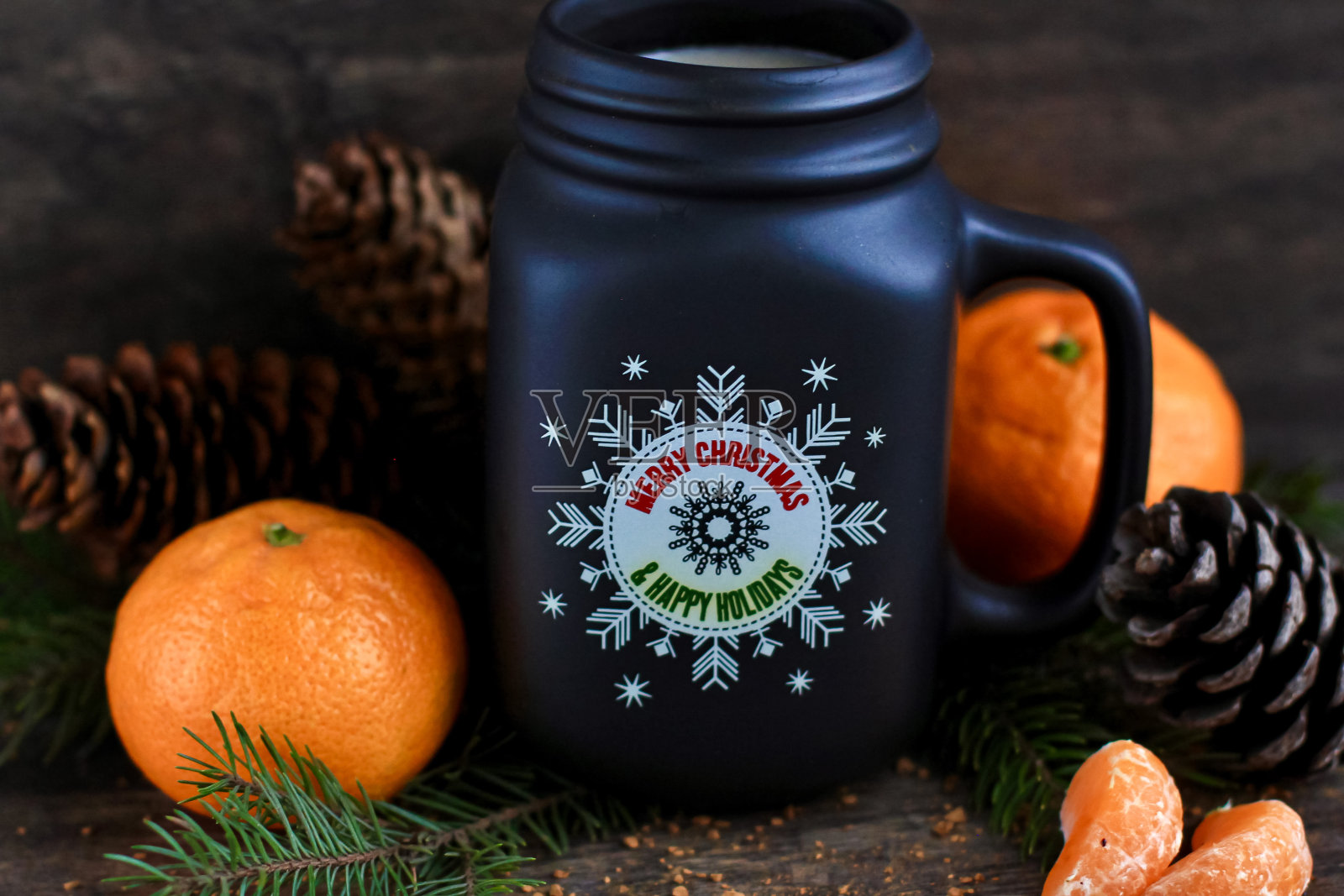 圣诞节，新年的概念与一杯热咖啡和牛奶在乡村木背景云杉树枝，球果，桔子。有选择性的重点。照片摄影图片