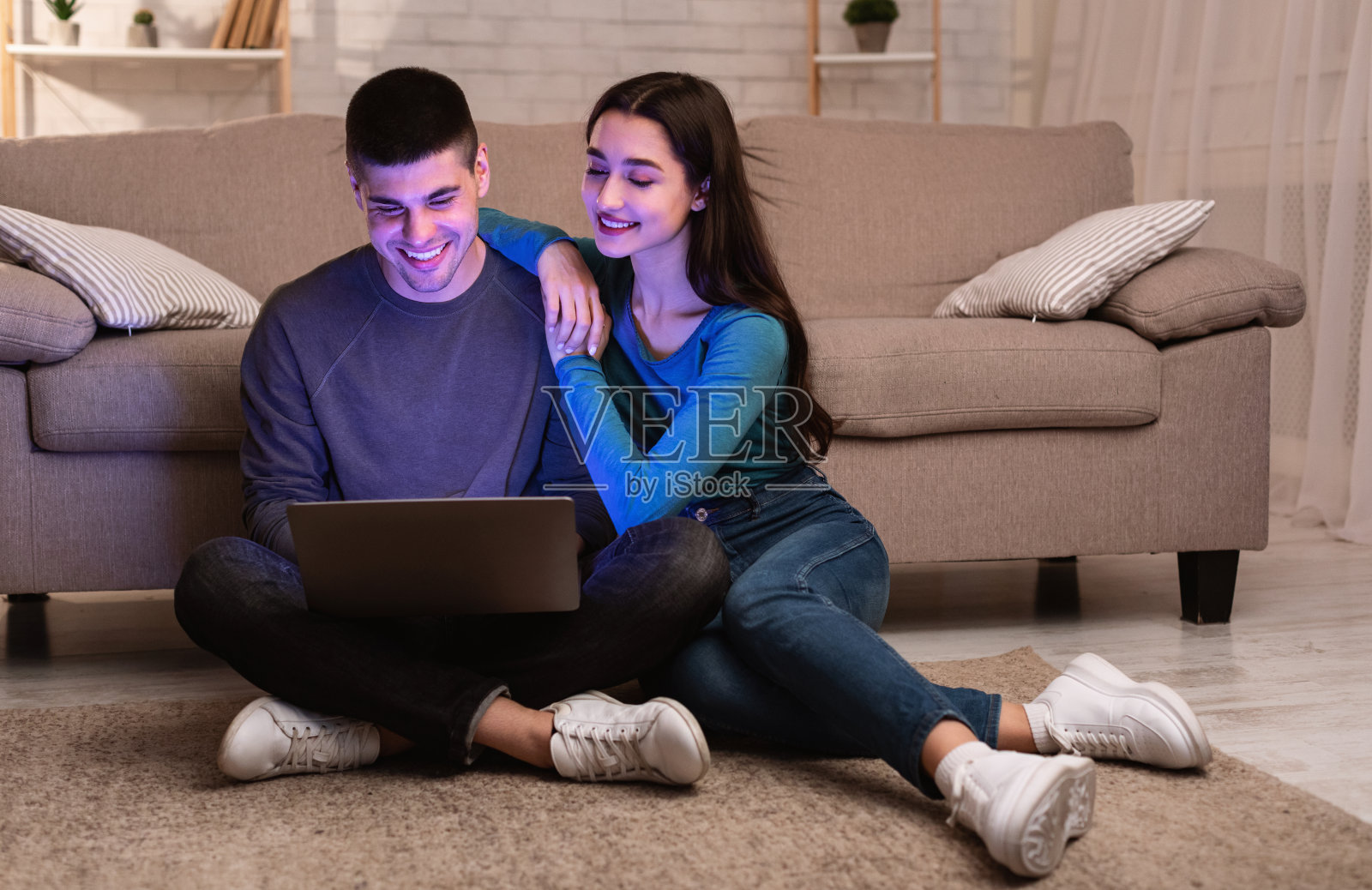 幸福的夫妇坐在地板上用电脑照片摄影图片