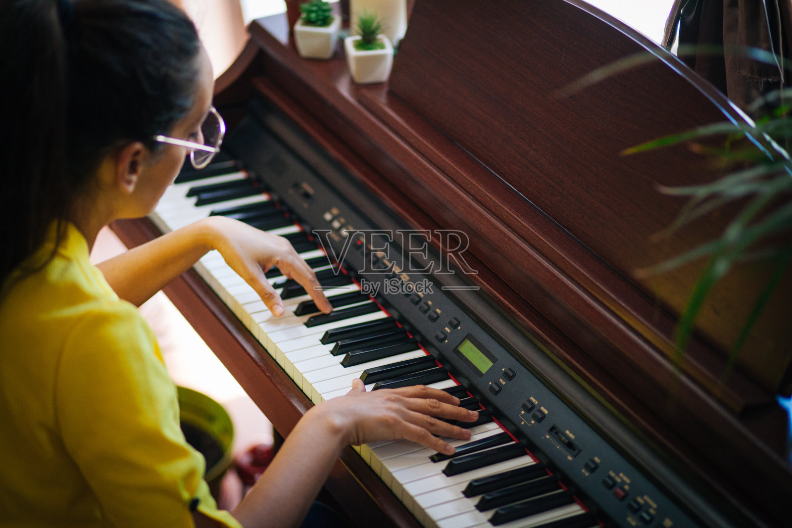 年轻的女钢琴家在自己家里的房间里谱曲照片摄影图片