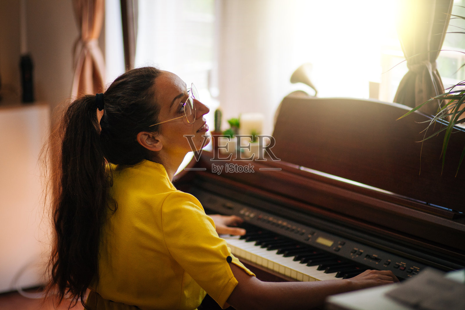 年轻的女钢琴家在自己家里的房间里谱曲照片摄影图片