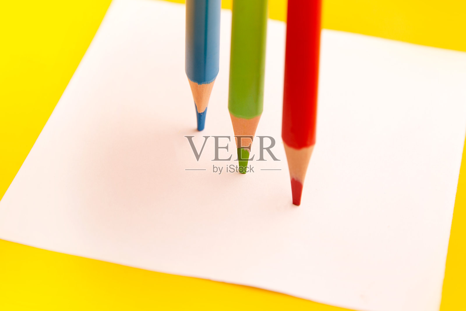 在白色的背景上用三支彩色铅笔在一张白纸上画节奏照片摄影图片