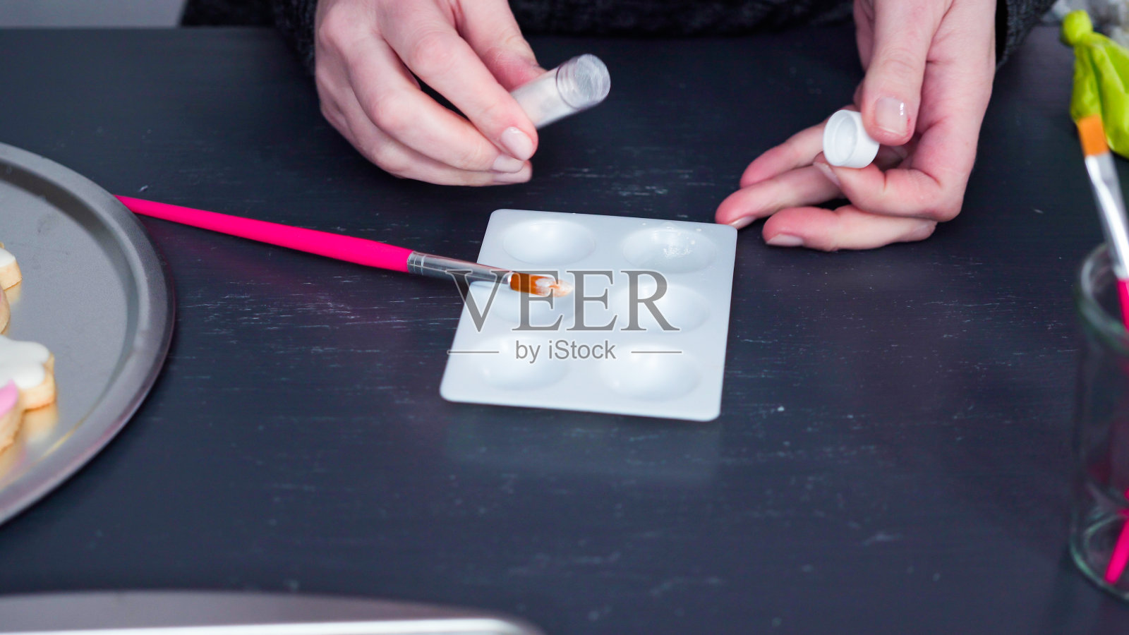 用皇家糖衣在独角兽甜饼上涂上食物粉。照片摄影图片