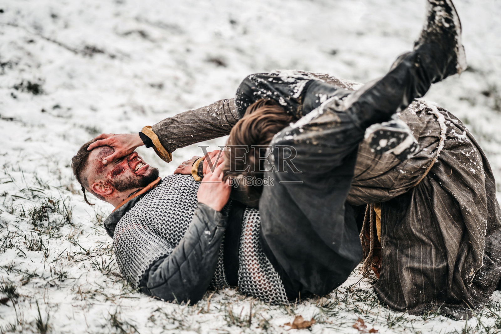 两个身穿铠甲的年轻战士在雪地上空手而战照片摄影图片