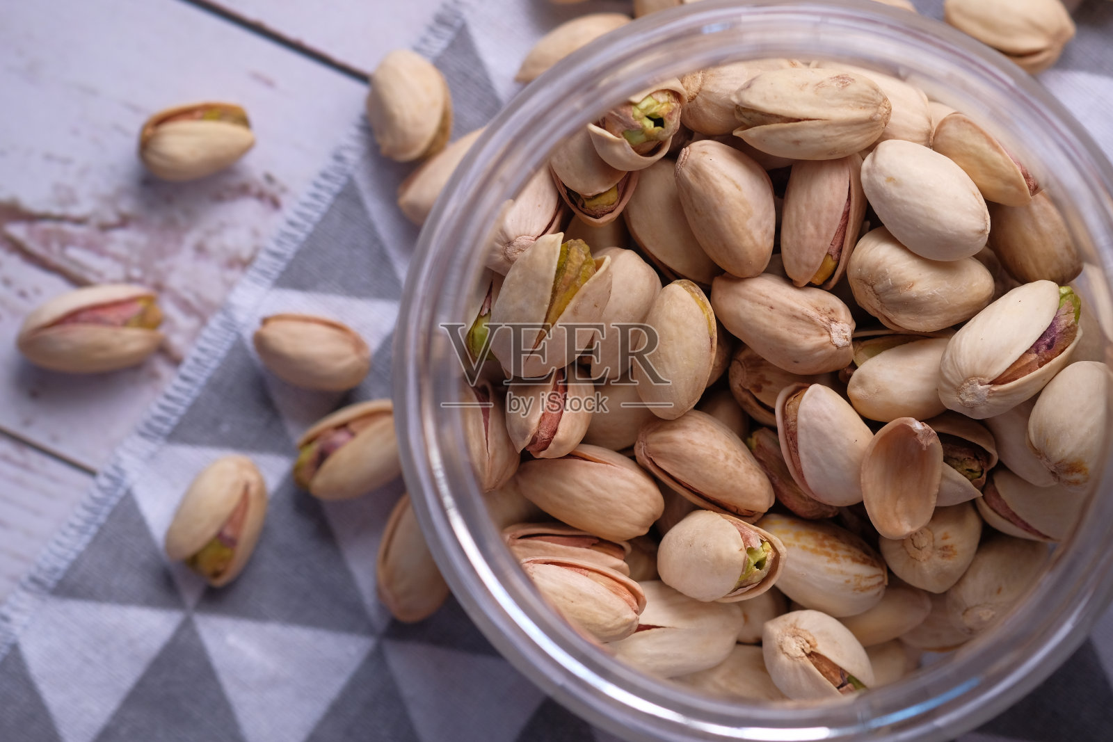 在桌子上的罐子里放上盐腌开心果照片摄影图片