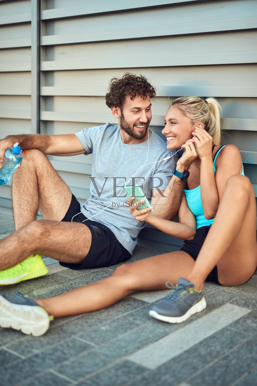 现代情侣在慢跑/锻炼时在人行道上停下来。照片摄影图片