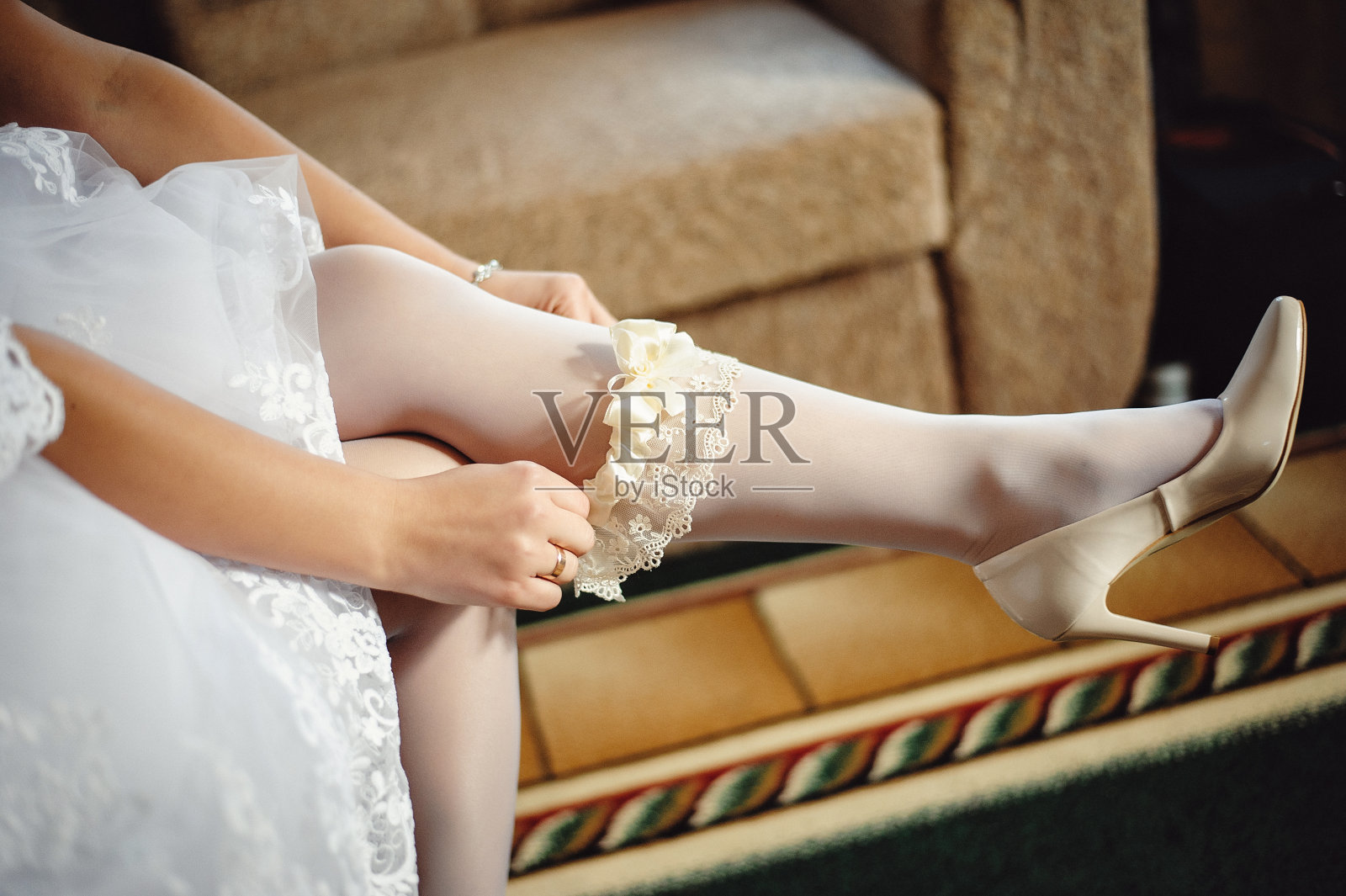 新娘腿上戴着吊袜带的特写。晨训的概念为婚礼。婚礼配件。袜带新娘照片摄影图片