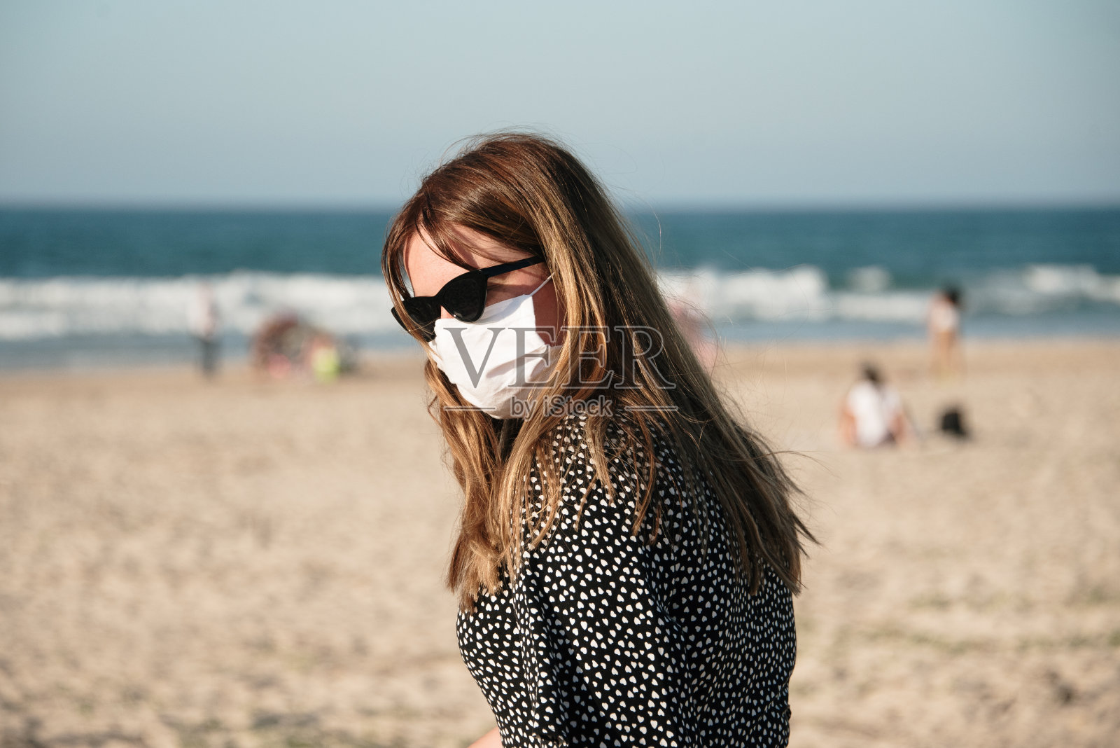 年轻女子在海滩上戴着防护面罩照片摄影图片