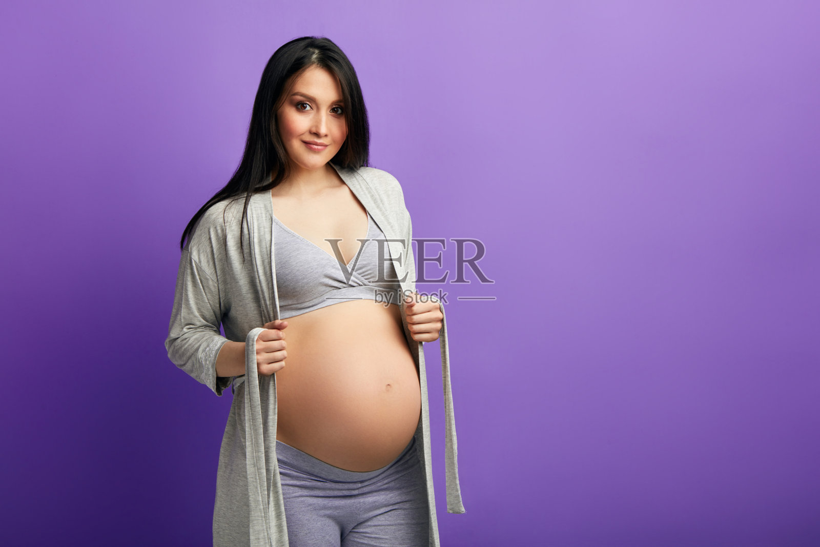 怀胎9个月的孕妇，抱着肚子照片摄影图片