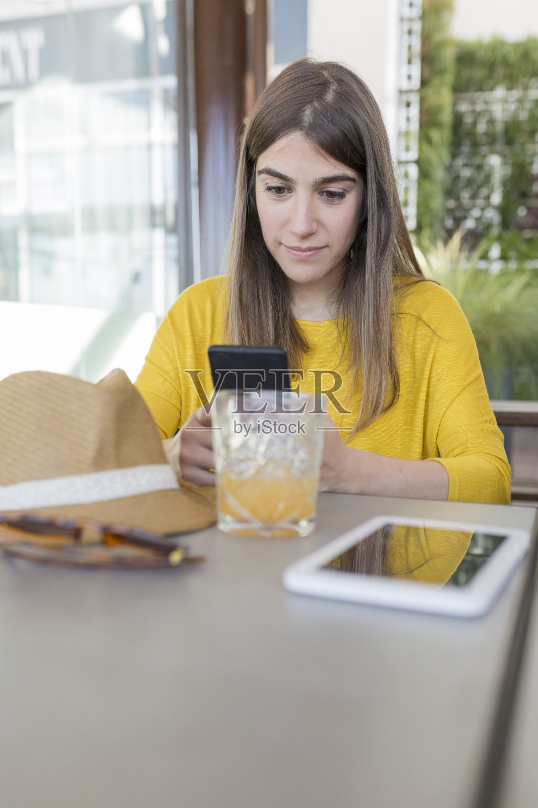 两个美女在餐厅吃早餐。他们笑着在平板电脑和手机上搜索信息。室内生活方式和友谊理念照片摄影图片