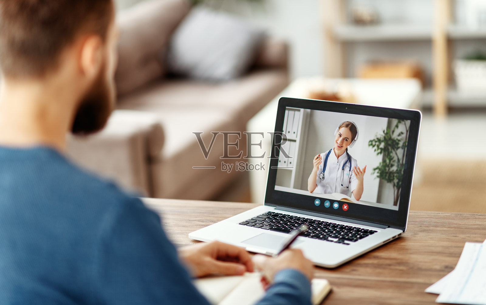 男人听着在线医生的话，做着笔记照片摄影图片