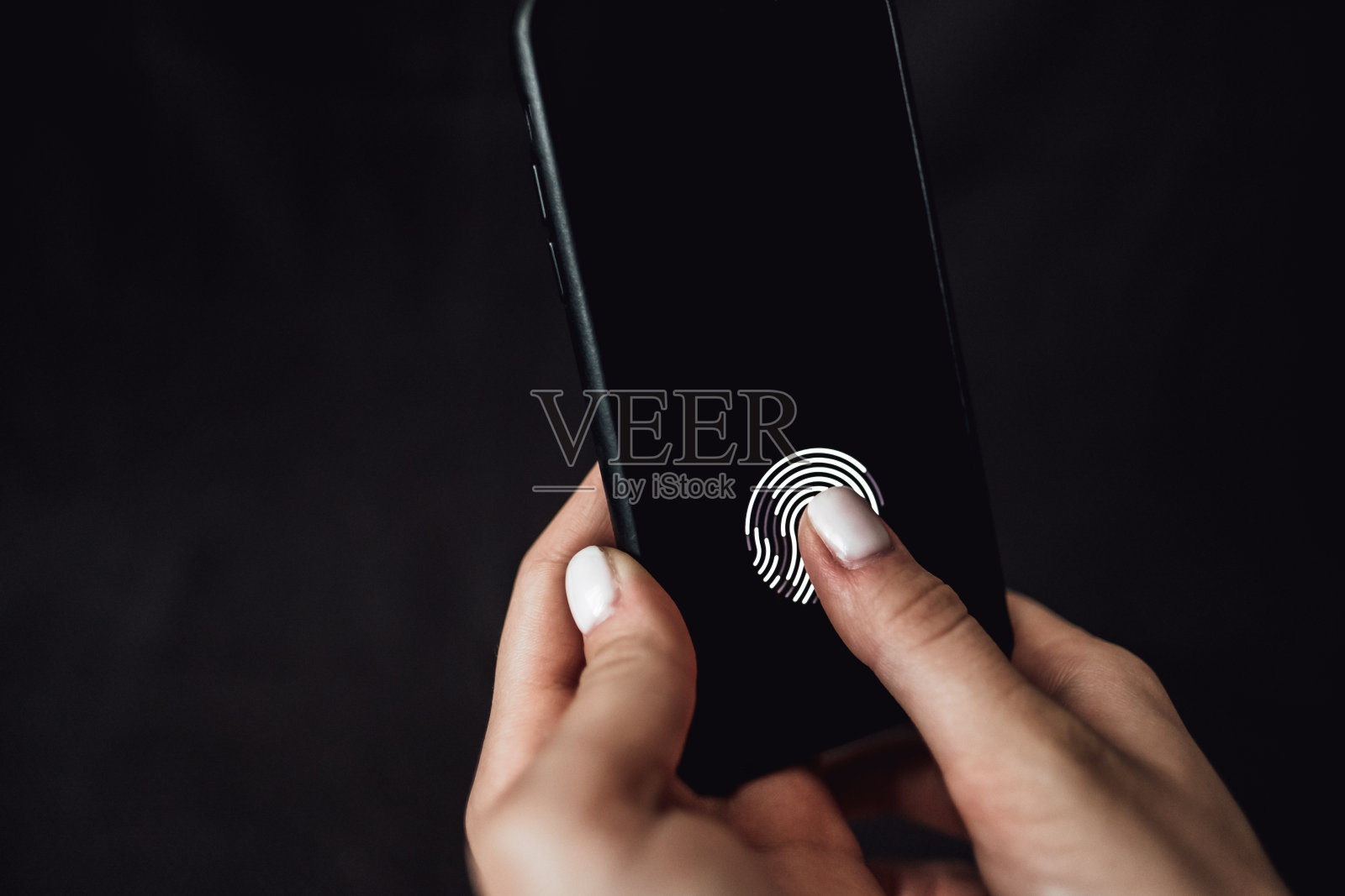 手持智能手机，屏幕上有指纹扫描仪。照片摄影图片