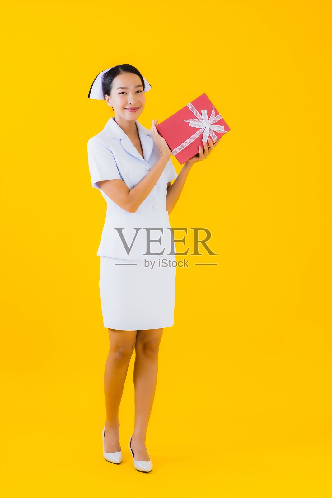 肖像美丽的年轻亚洲女子泰国护士展示红色礼盒照片摄影图片