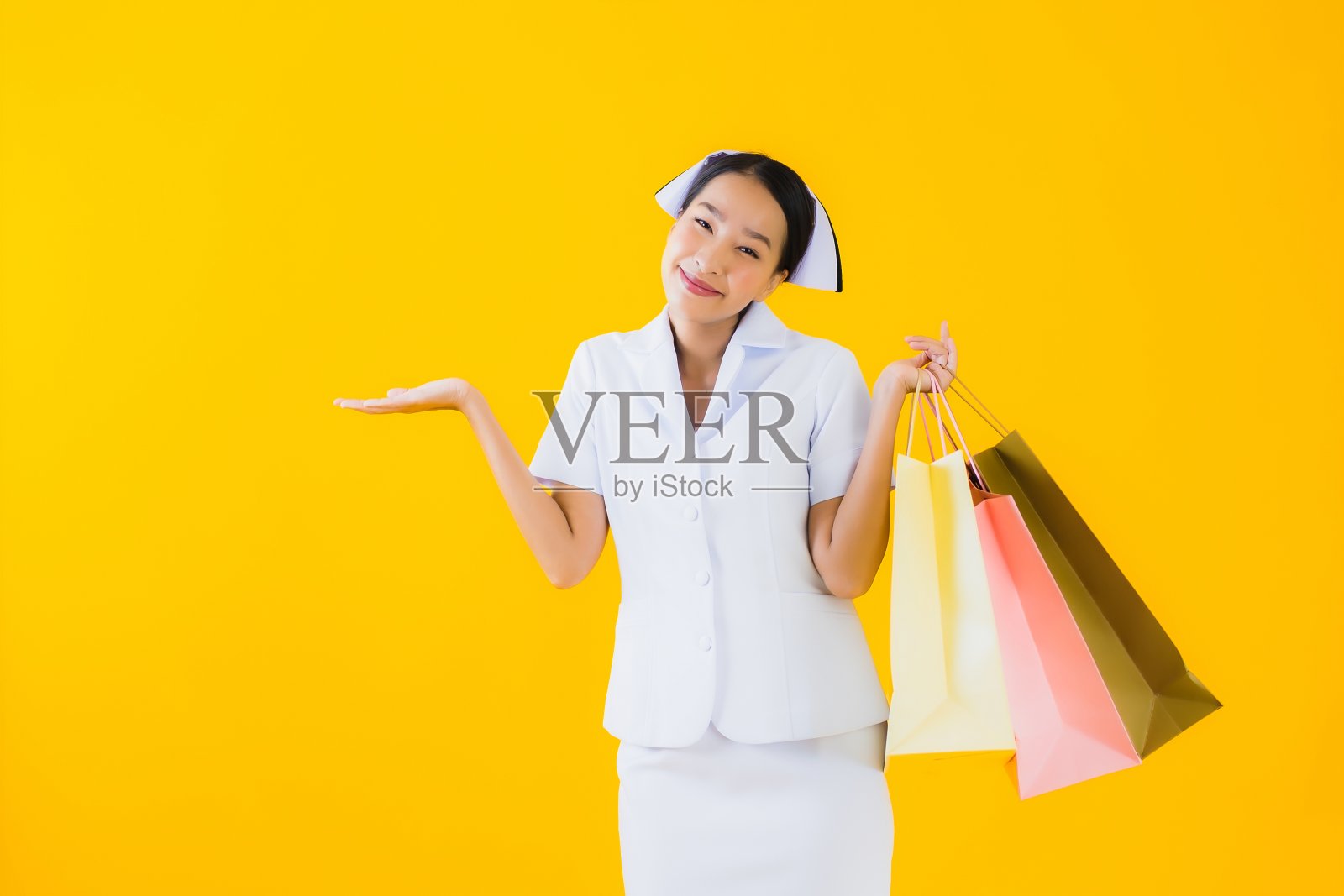 肖像美丽的年轻亚洲妇女泰国护士与购物袋和信用卡照片摄影图片