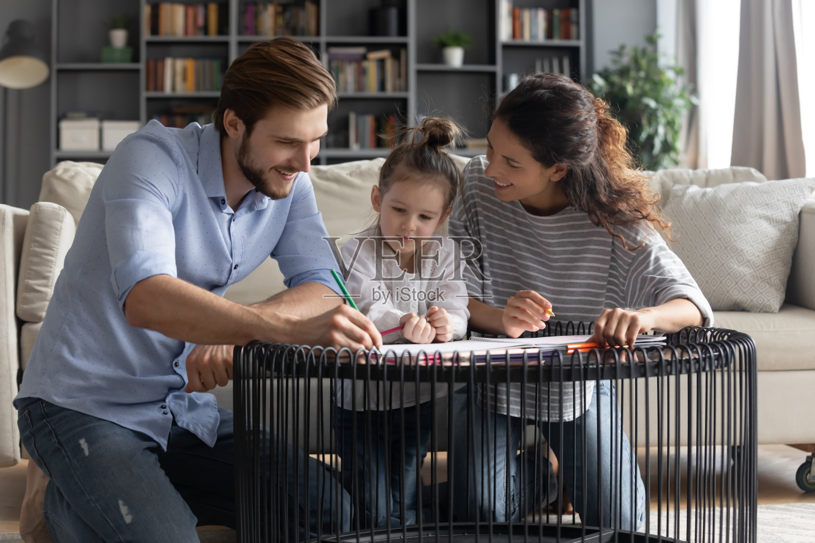 幸福的年轻家庭和小女儿一起画画照片摄影图片
