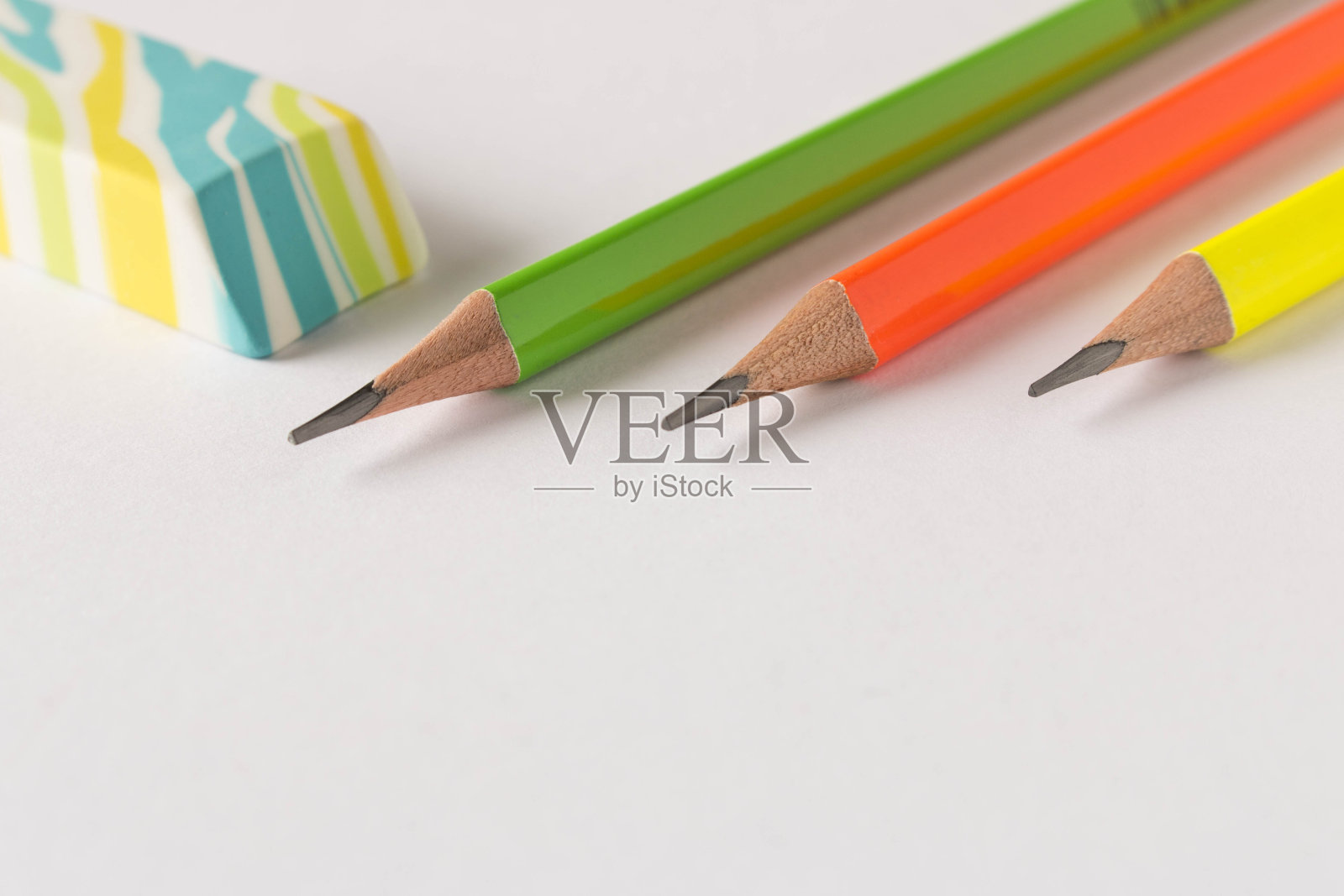 彩色的橡皮和简单的铅笔在一个明亮的背景。关闭了。有选择性的重点。照片摄影图片