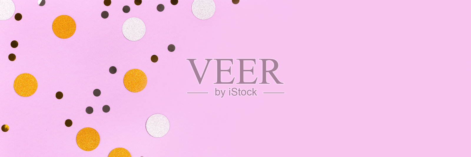 金色和银色的五彩纸屑散落在紫色柔和的背景上。照片摄影图片