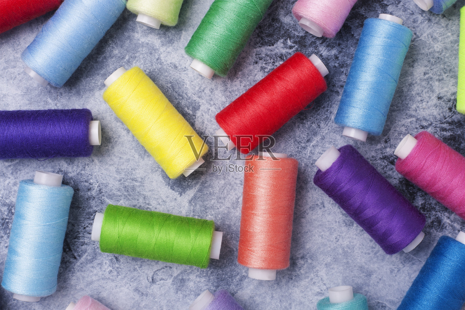 彩色线轴，缝纫套装。在灰色混凝土背景下。文本。照片摄影图片