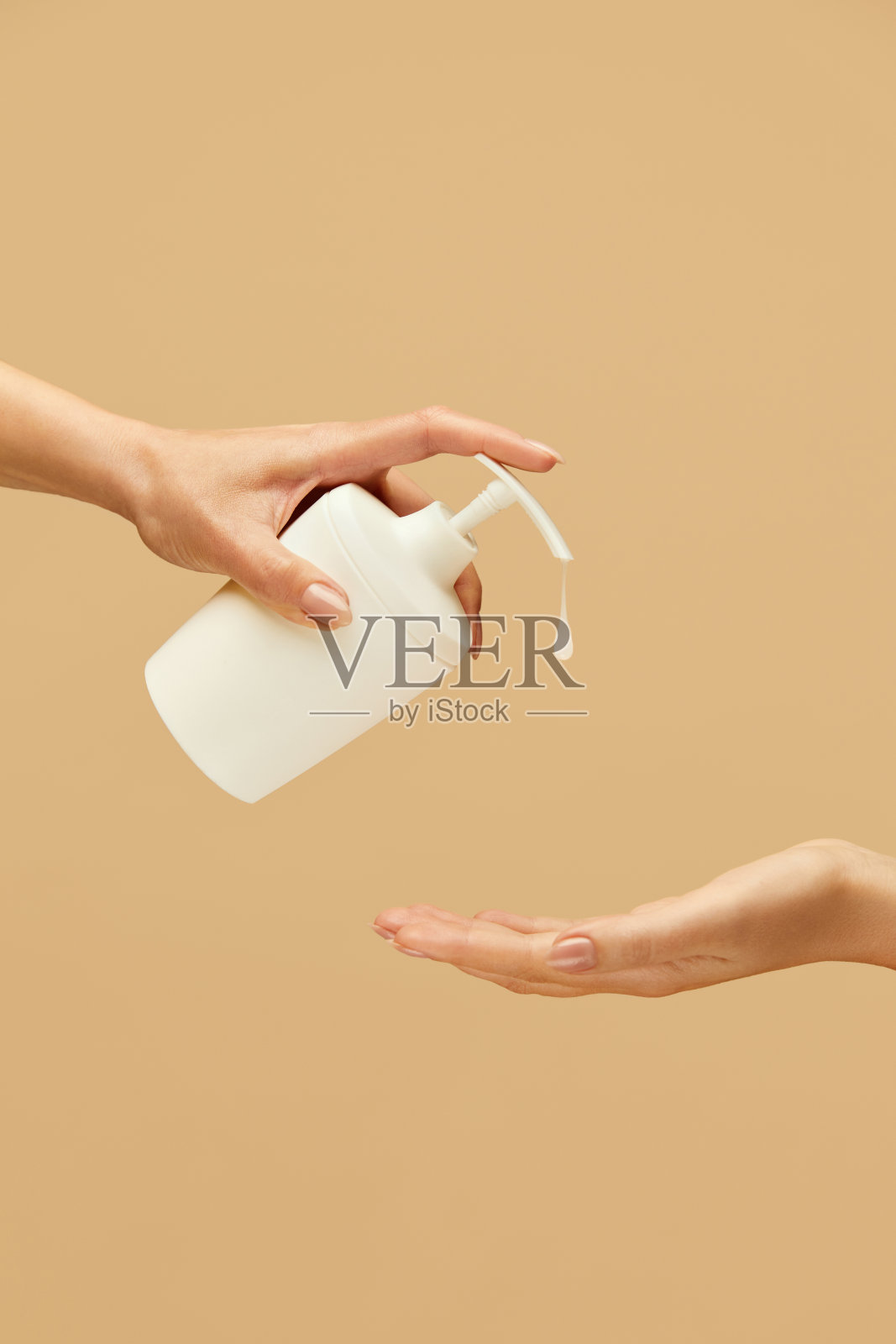 卫生。使用洗手液对抗米色背景。日常使用抗菌产品预防病毒和保持健康。照片摄影图片