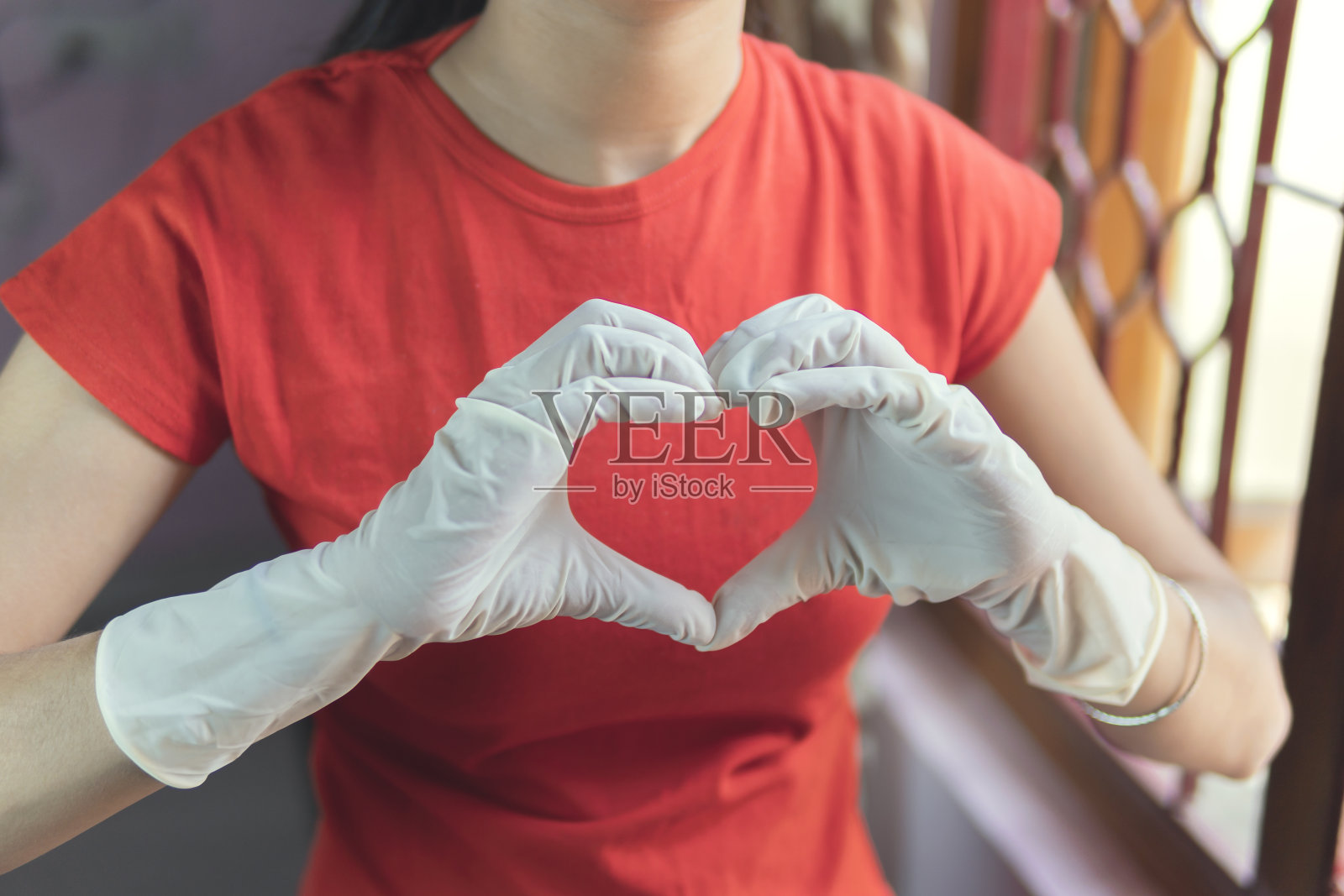 这个女孩在家里保护自己不受手套的伤害。自我隔离。Covid-19大流行。照片摄影图片