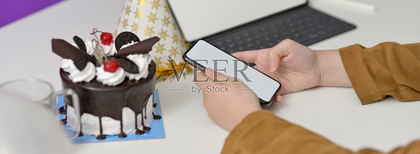 侧视图在线生日派对的概念，女性视频呼叫模拟智能手机在白色的桌子照片摄影图片