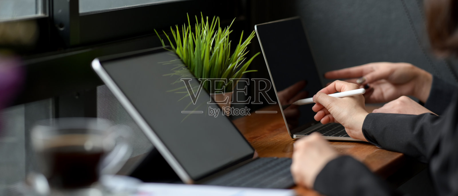 两个商人的侧视图一起工作在木酒吧与数字设备照片摄影图片